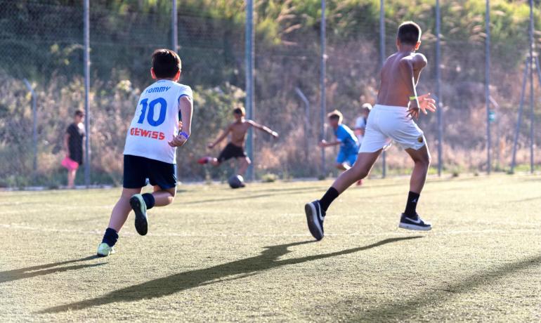 Kinder spielen Fußball, Energie und Freude in der Sonne.