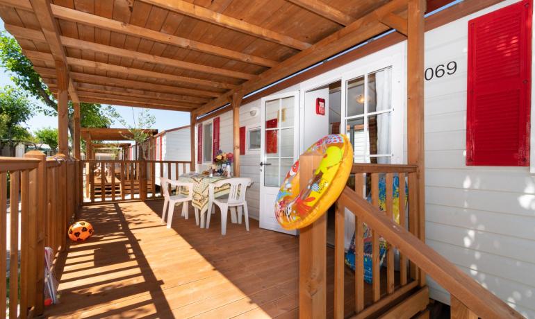 Wooden porch with table, chairs, and float.