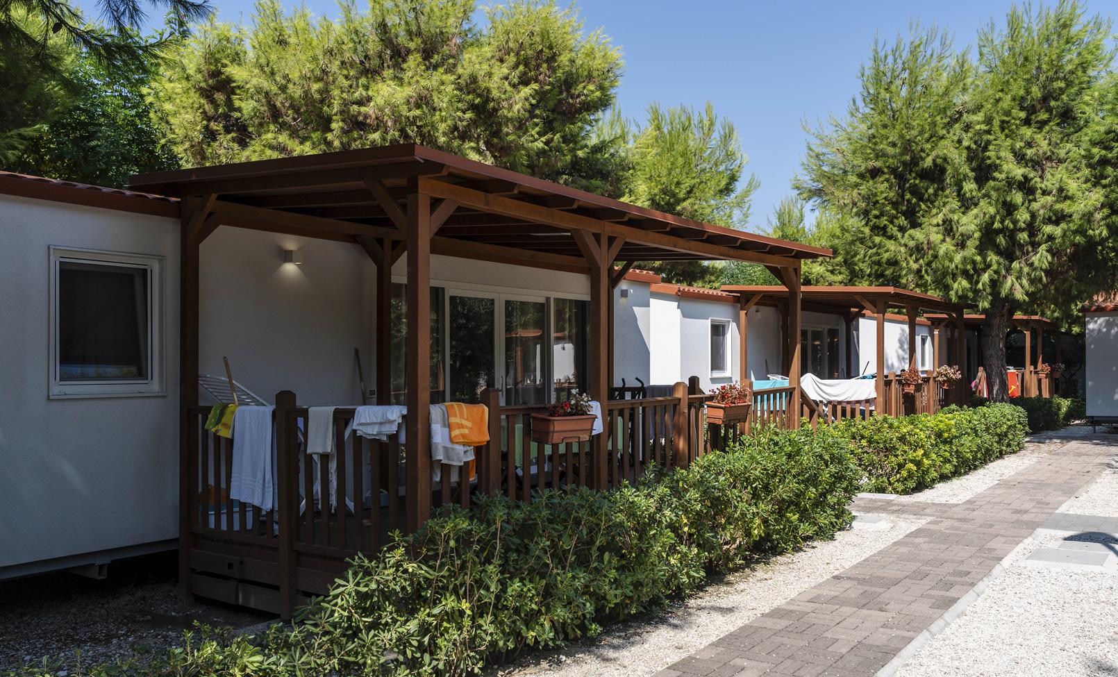 Bungalow con veranda in un campeggio immerso nel verde.