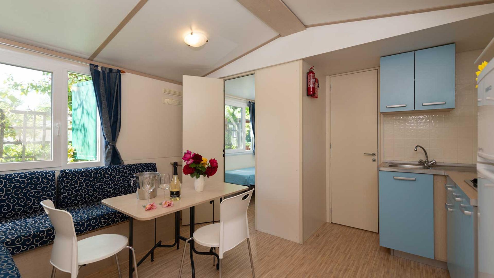 Petite cuisine moderne avec table et canapé bleu.