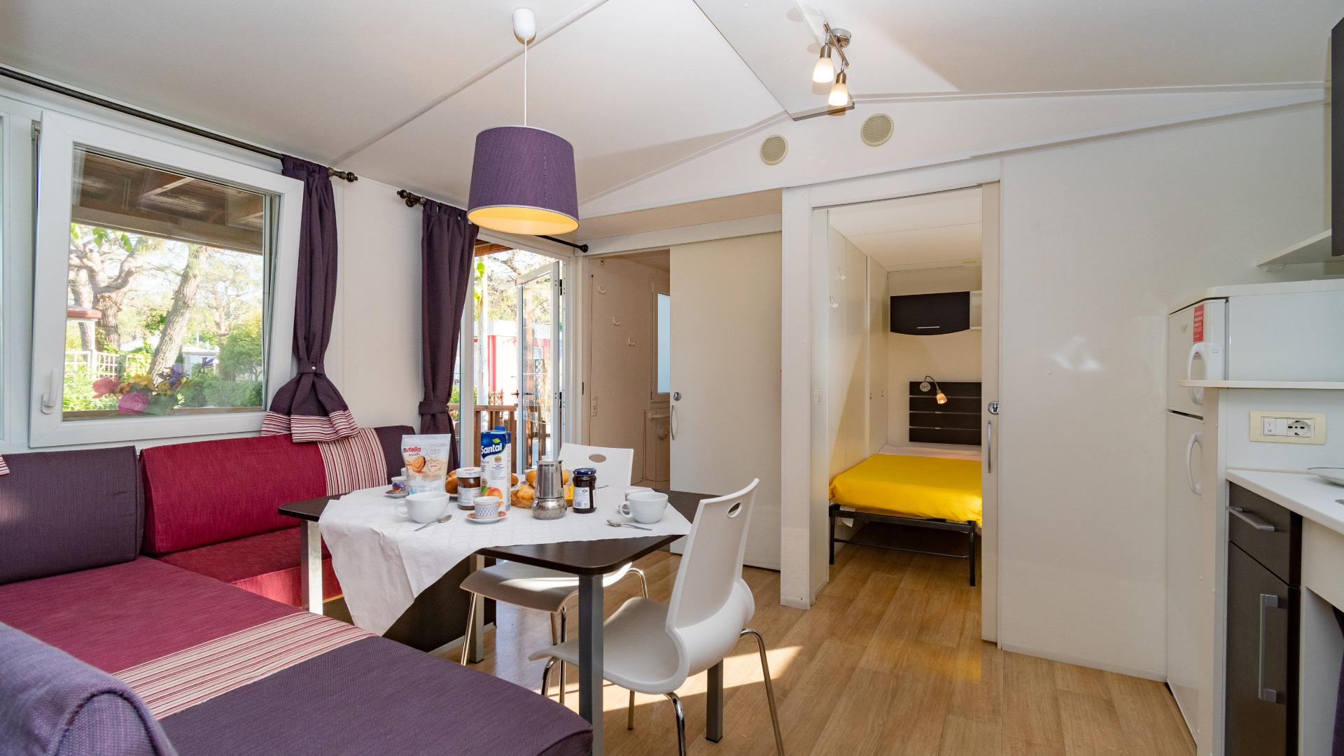 Interno moderno con cucina, tavolo e divano.