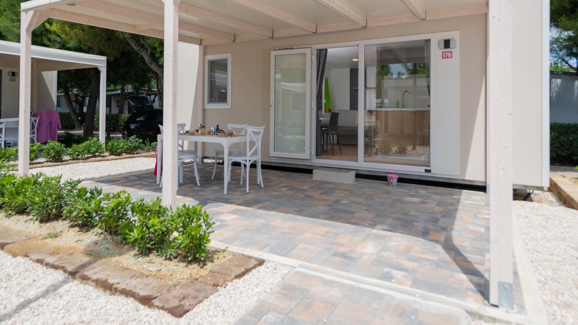 Casetta moderna con patio e giardino.