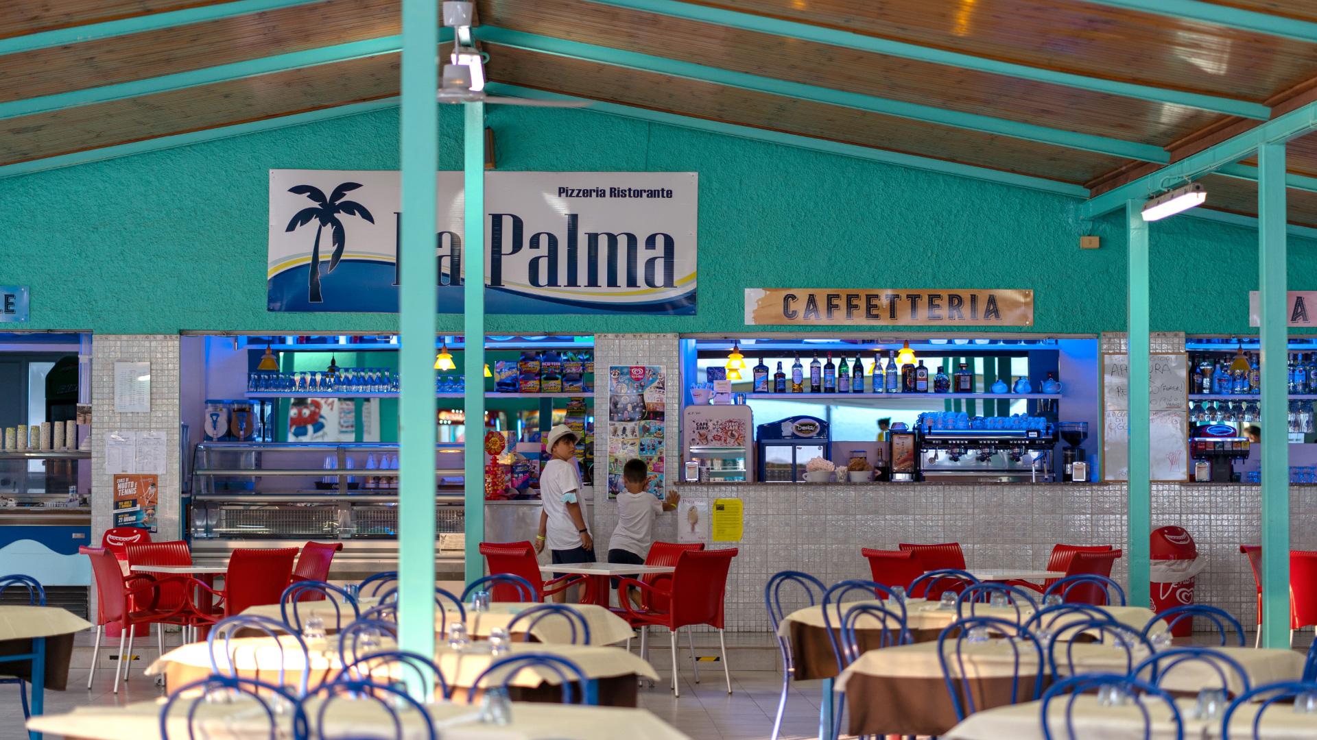 Pizzeria e caffetteria con sedie colorate e decorazioni vivaci.
