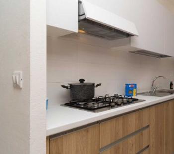 Moderna cucina con mobili in legno e fornello a gas.
