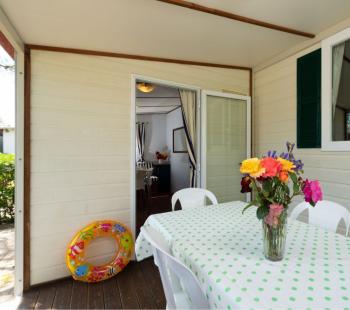 Veranda con tavolo, fiori e salvagente colorato.