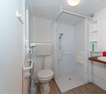 Bagno accessibile con doccia, lavabo e servizi igienici.