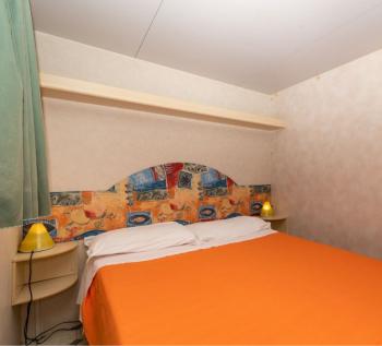 Camera da letto semplice con letto matrimoniale e lampade.