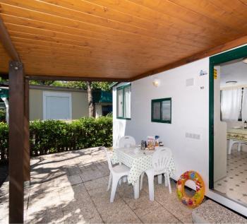 Veranda con tavolo e sedie, atmosfera rilassante all'aperto.