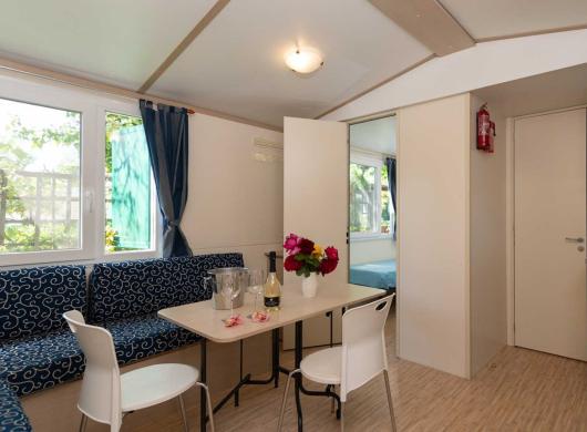 Piccola cucina moderna con tavolo e divano blu.