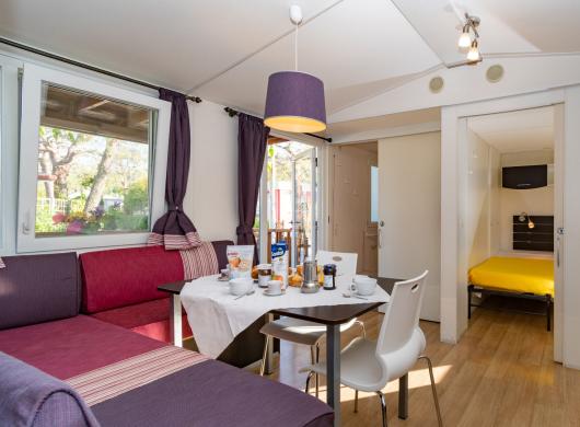 Interno moderno con cucina, tavolo e divano.