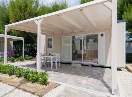 Casetta moderna con patio e giardino.