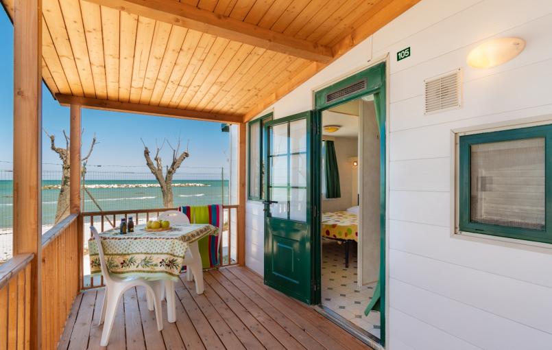 Veranda sul mare con tavolo e sedie, vista spiaggia.