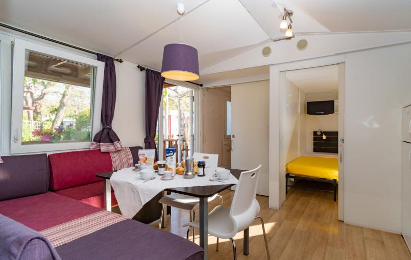 Interno moderno con cucina, tavolo e divano.
