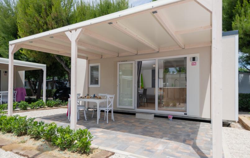 Casetta moderna con patio e giardino.