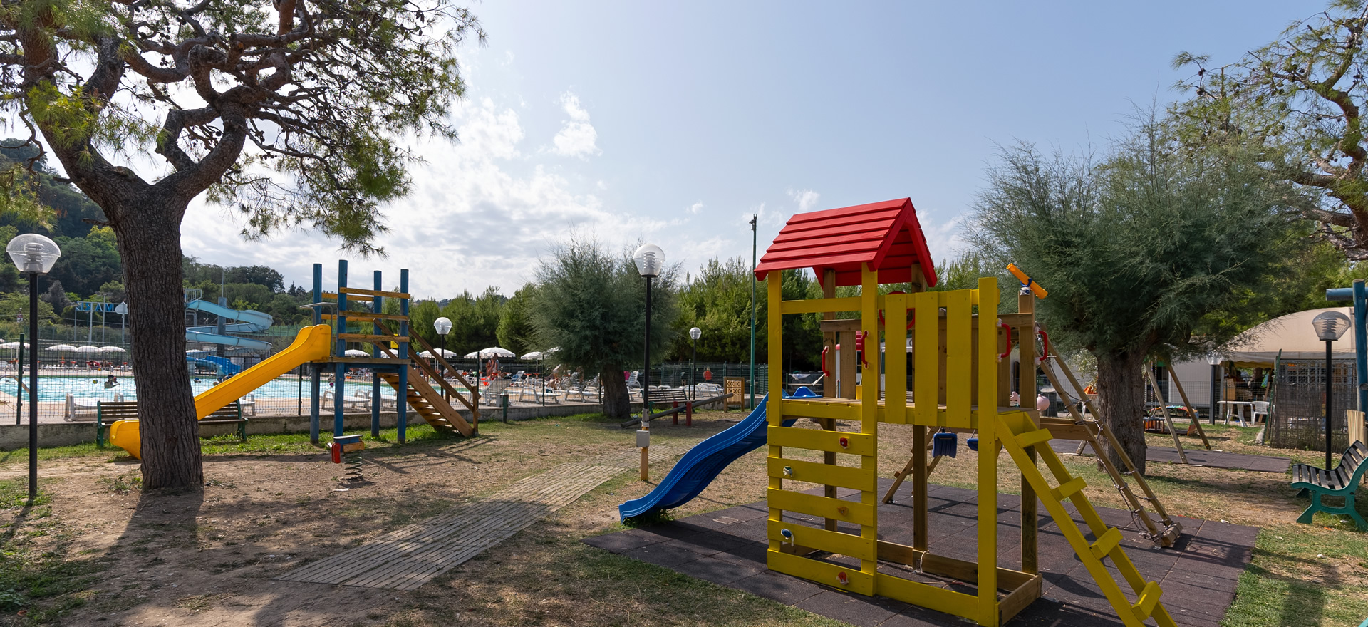 Parco giochi con scivoli vicino a una piscina all'aperto.
